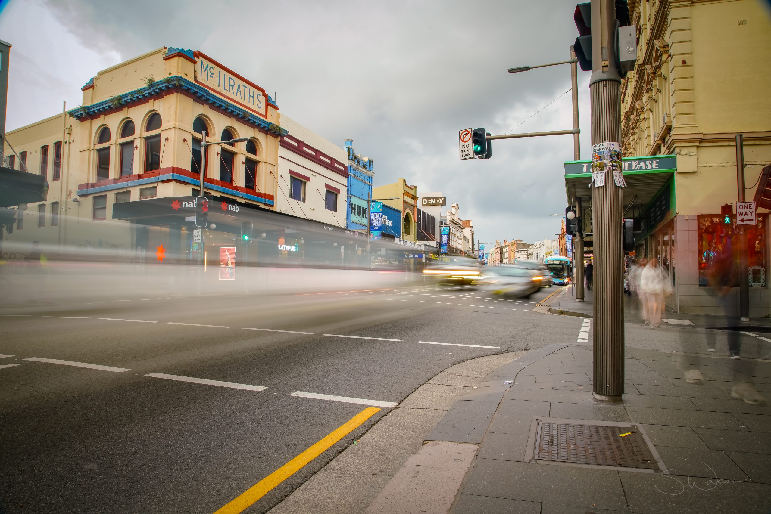 Cars speed by at a busy intersection in Newtown, Sydney, Australia.Travel